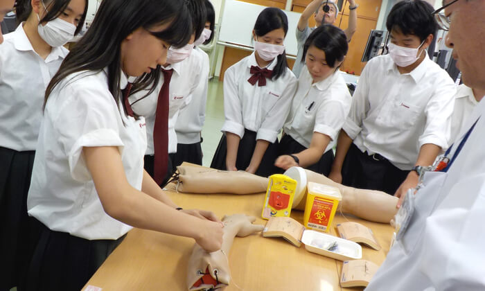 写真:高校生数人が採血の授業を体験している