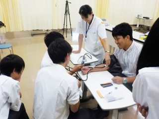 血圧を測定する生徒 写真:血圧を測定する生徒