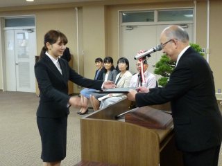 写真：塩田学長から修了証を手渡される修了生