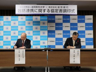 協定書に署名する塩田学長と滋賀銀行高橋頭取 写真:協定書に署名する塩田学長と滋賀銀行高橋頭取