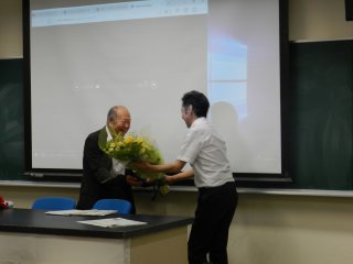 写真：河内教授による花束贈呈の様子