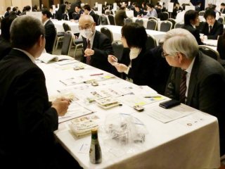 写真：サプライヤー企業と熱心に商談をする本学出席者