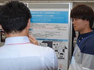 ポスターの前で説明する松井温哉氏 写真:ポスターの前で説明する松井温哉氏