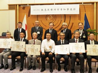 三日月知事と受賞者（下段右から三人目が辻川理事、二人目が辻田講師）