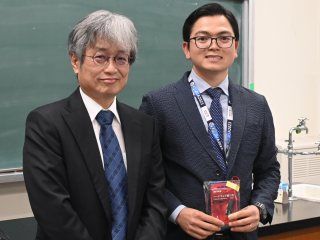 Ha with Professor Aimi, receiving the prize for participation