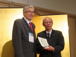 授賞式の様子【Lars-Erik Gelin賞】 写真左：スカンジナビア・マイクロサージャリー・アカデミー Mihai Oltean博士、写真右：上本学長